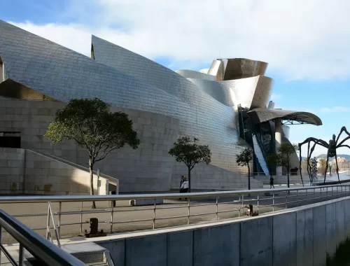 Het Guggenheim Museum in Bilbao met het spinnenbeeld Maman aan de rivier