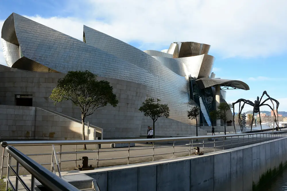 Het Guggenheim Museum in Bilbao met het spinnenbeeld Maman aan de rivier