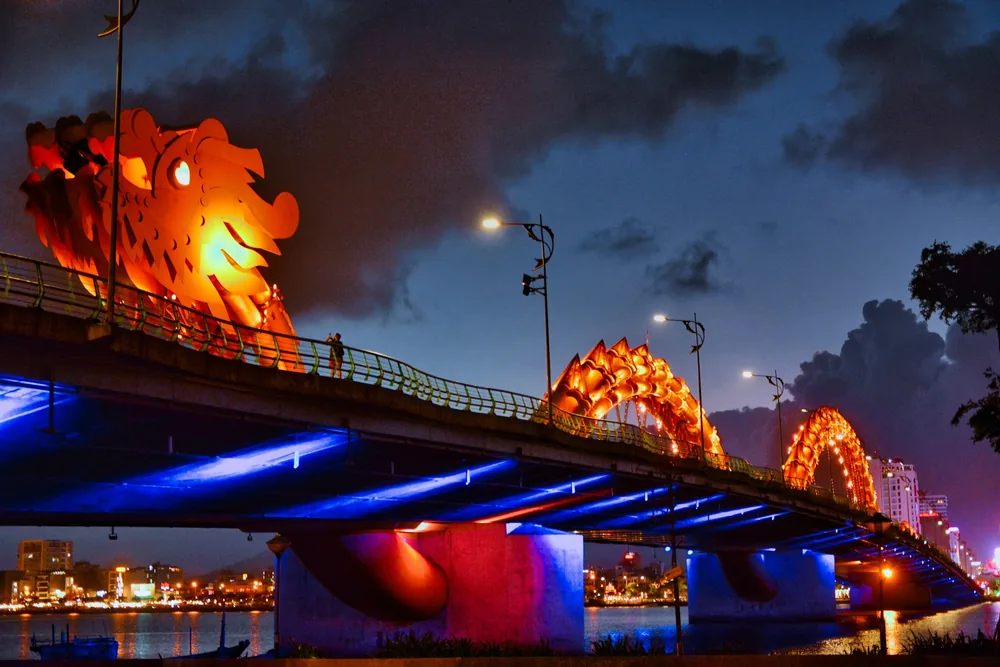 De verlichte Drakenbrug over de Hanrivier in Da Nang bij zonsondergang