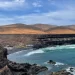 Turquoise zee en rotsige kust van Fuerteventura met bruine bergen op de achtergrond