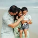 Ouders met hun peuter lachend op het strand tijdens een kindvriendelijke vakantie