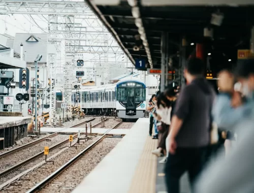 Reizigers wachten netjes in de rij op het perron van een Japans treinstation terwijl de trein binnenrijdt