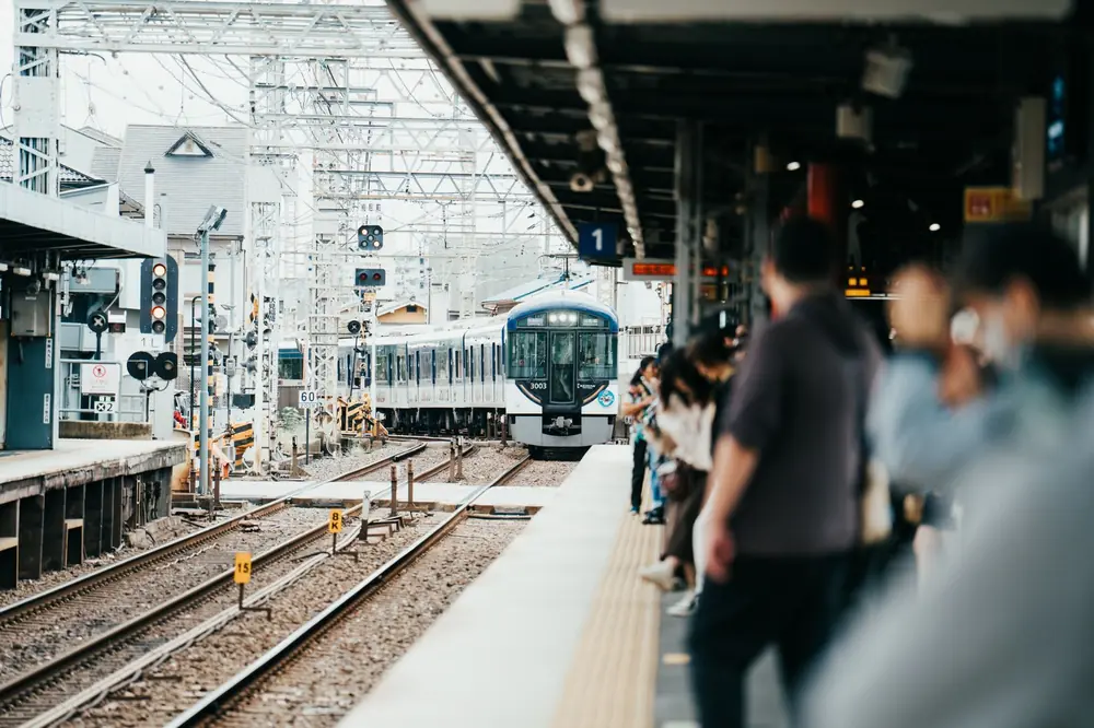 Reizigers wachten netjes in de rij op het perron van een Japans treinstation terwijl de trein binnenrijdt