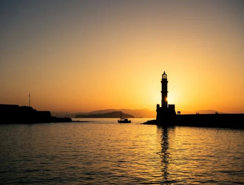 De vuurtoren van de oude haven van Chania op Kreta bij zonsondergang