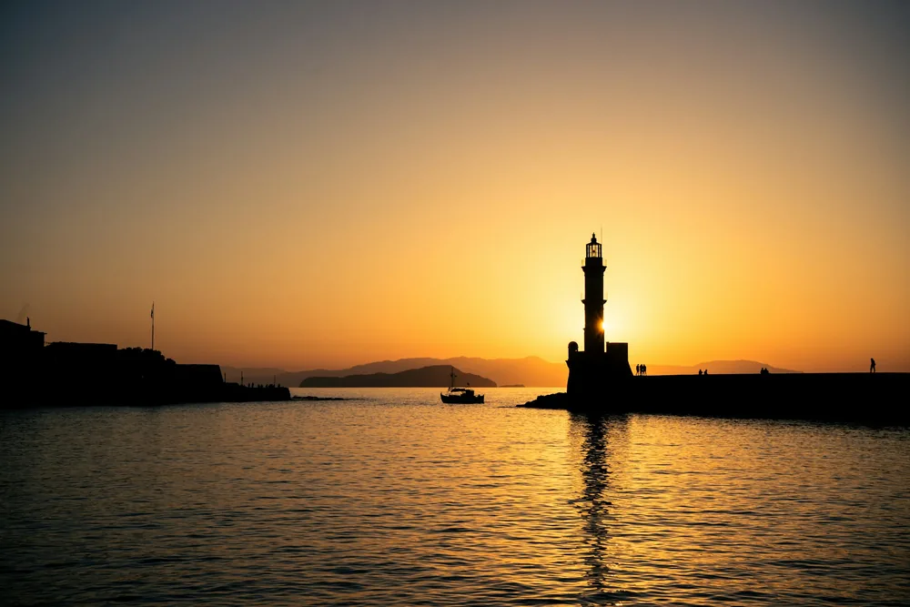 De vuurtoren van de oude haven van Chania op Kreta bij zonsondergang
