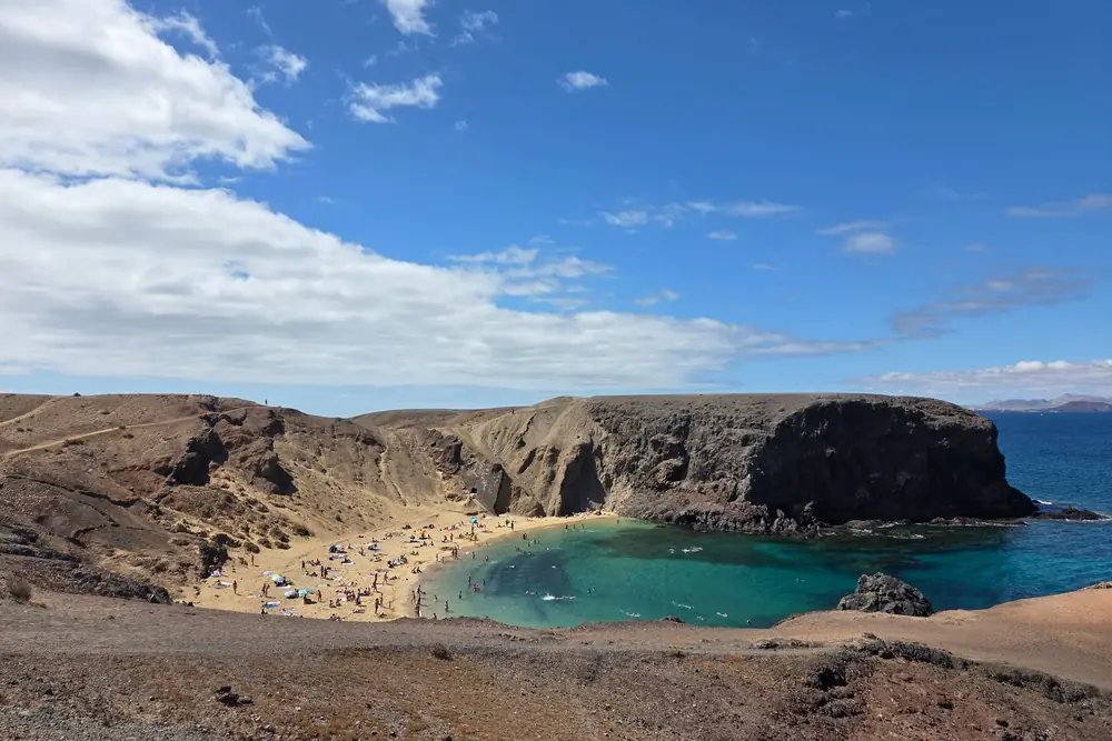 Het baaitje van Papagayo op Lanzarote met licht zand en turquoise water tussen bruine rotsen