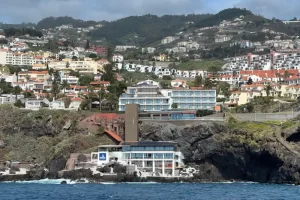 Uitzicht vanaf zee op de kust van Funchal op Madeira met witte huizen tegen groene bergen