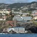 Uitzicht vanaf zee op de kust van Funchal op Madeira met witte huizen tegen groene bergen