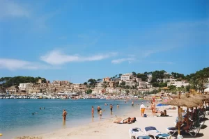 Zonnig strand in de baai van Port de Sóller op Mallorca met bergen op de achtergrond