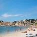 Zonnig strand in de baai van Port de Sóller op Mallorca met bergen op de achtergrond