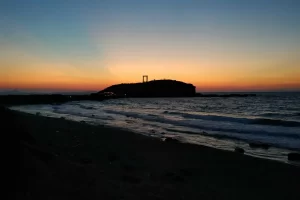Zonsondergang bij de Portara op Naxos met de zee op de voorgrond