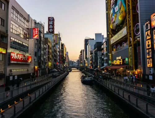 Het Dotonbori-kanaal in Osaka met neonreclames in de avondschemering
