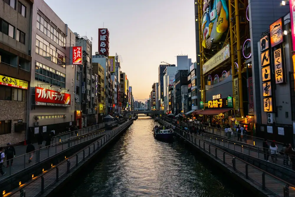 Het Dotonbori-kanaal in Osaka met neonreclames in de avondschemering
