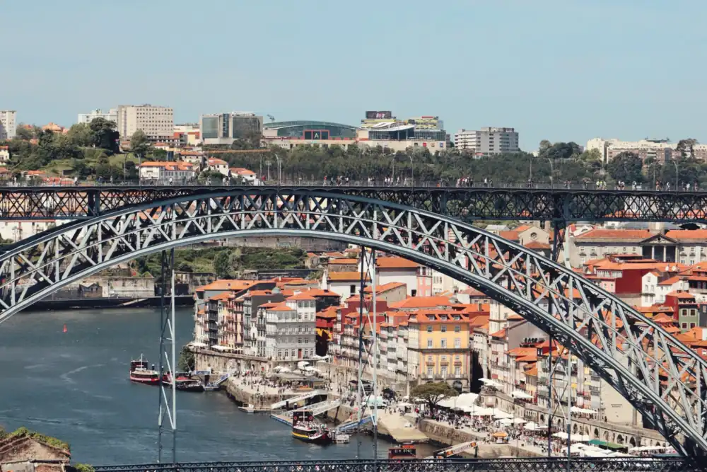 De ijzeren brug Ponte Dom Luís I over de Douro met de kleurrijke huizen van Ribeira in Porto