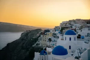 Witte huisjes en blauwe koepels van Oia op Santorini bij zonsondergang