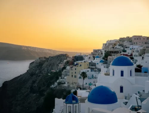 Witte huisjes en blauwe koepels van Oia op Santorini bij zonsondergang