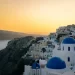 Witte huisjes en blauwe koepels van Oia op Santorini bij zonsondergang