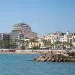 Strand en witte huizen met palmbomen aan de boulevard van Sitges